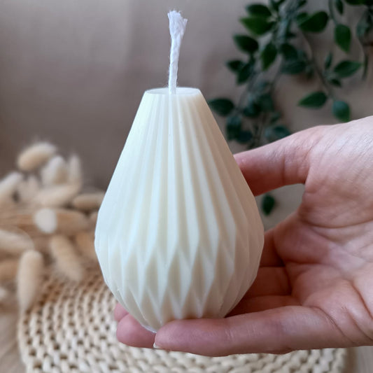 Vela natural de soja en forma geométrica sostenida en la mano