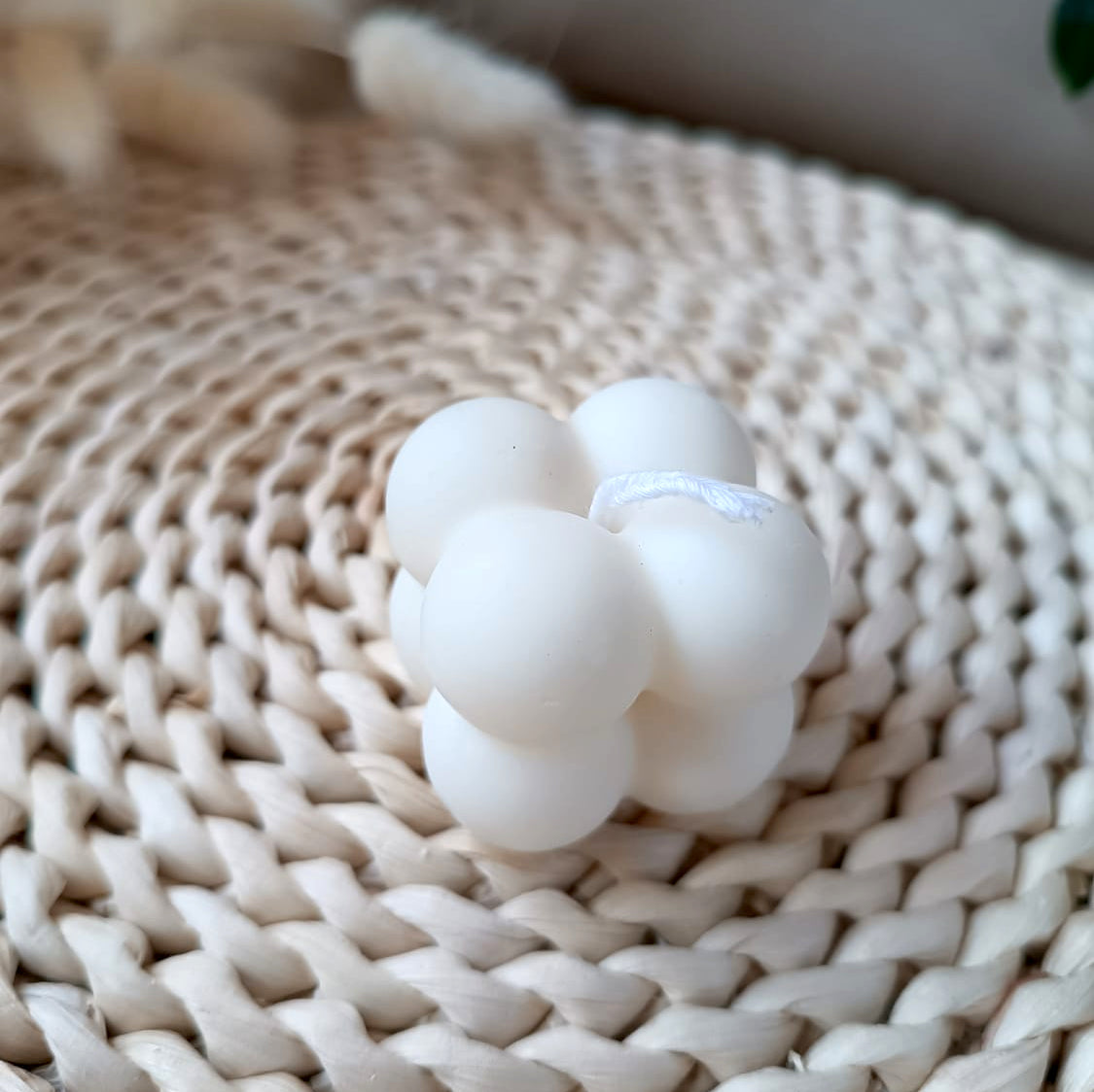 Vela decorativa de soja en forma de cubo con relieve de burbujas estilo minimalista y fondo neutro