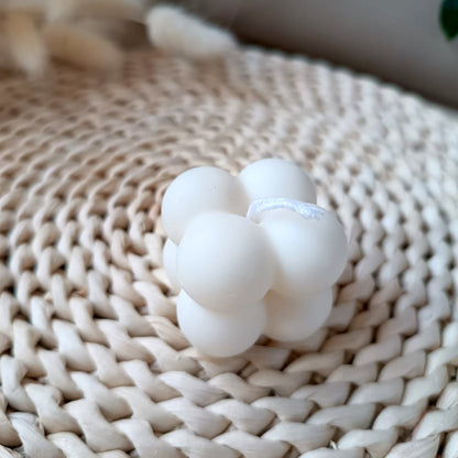 Vela decorativa de soja en forma de cubo con relieve de burbujas estilo minimalista y fondo neutro