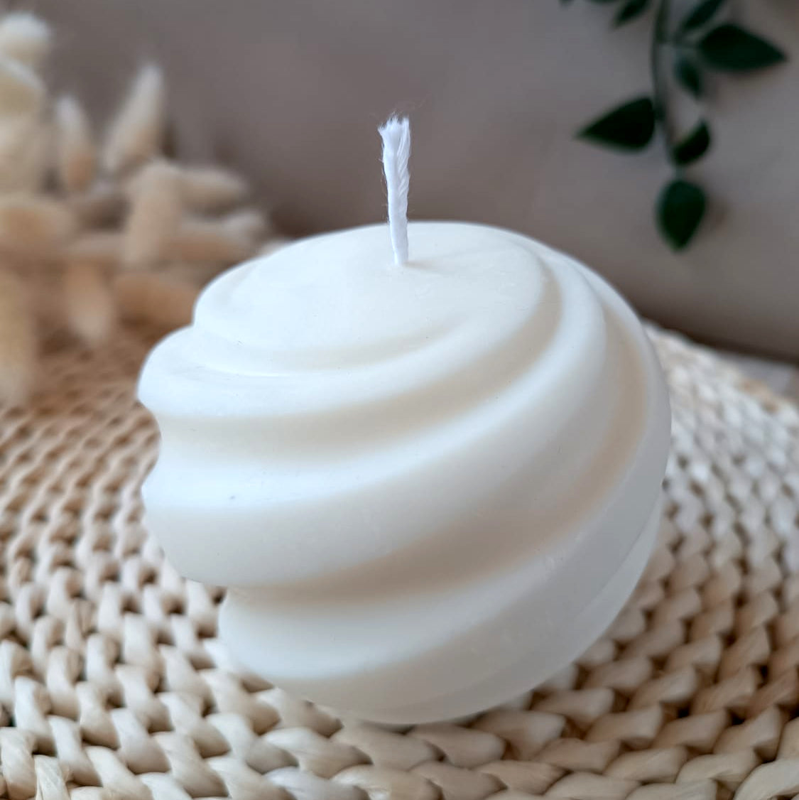 Vela decorativa natural de soja redonda grande con diseño espiral estilo minimalista y fondo neutro