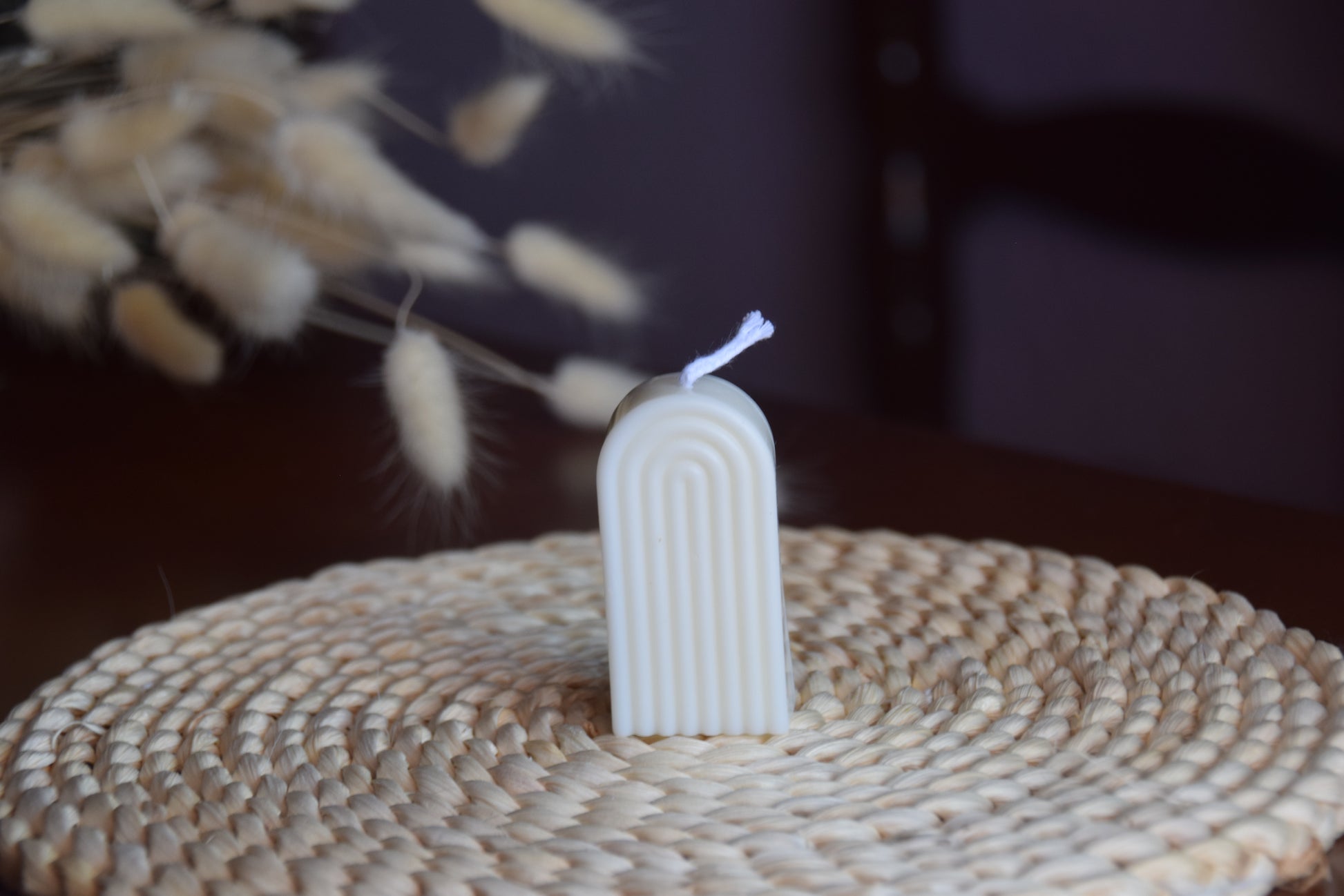 Vela decorativa mini arco con pabilo de algodon en fondo rustico.