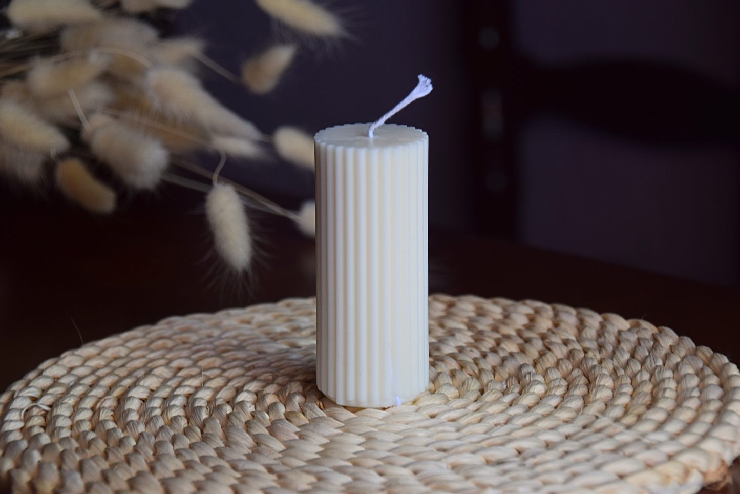 Vela decorativa pilar acanalado pequeño con pabilo de algodon en fondo rustico.