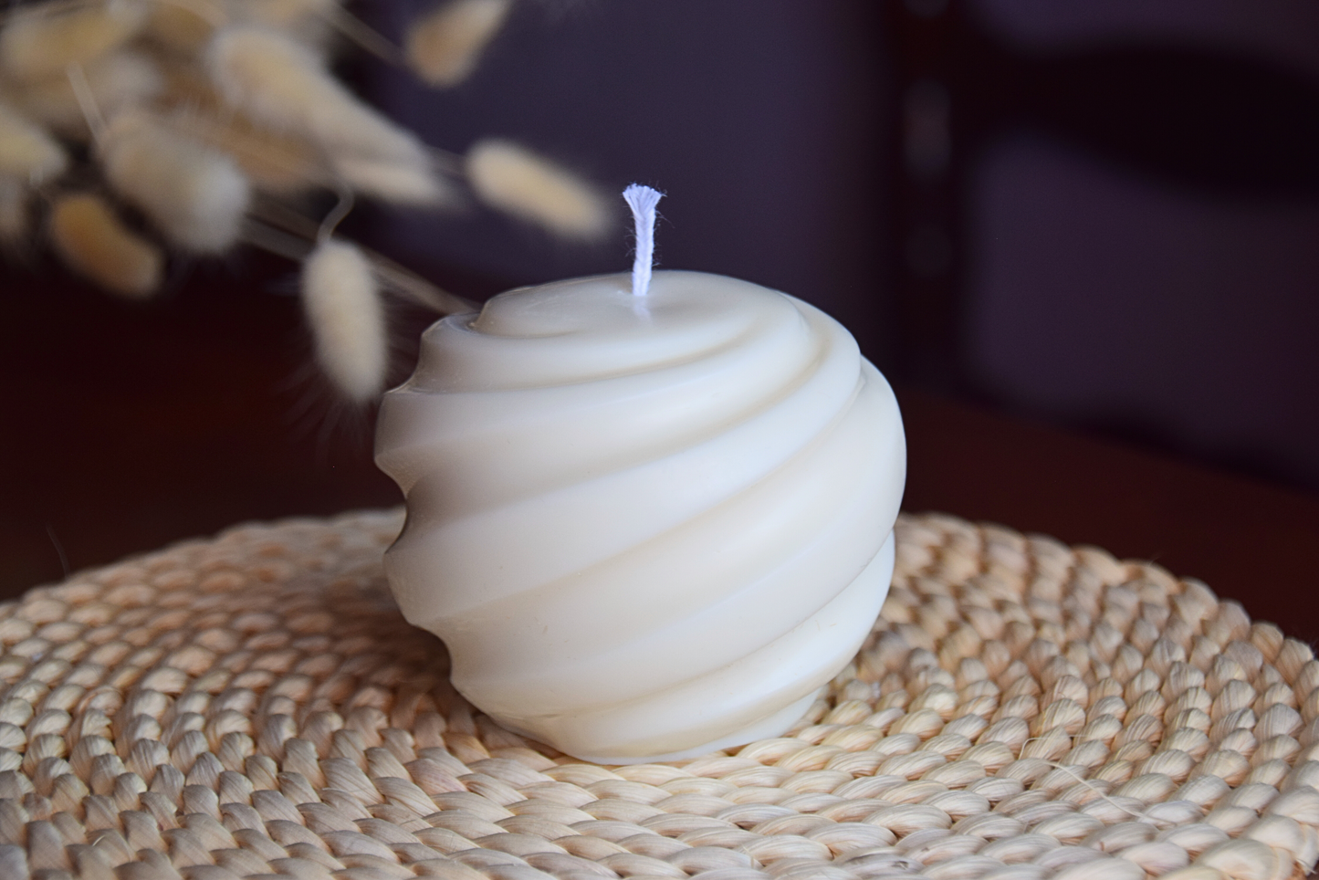 Vela decorativa grande en forma de tirabuzon y pabilo de algodon con fondo rustico. 