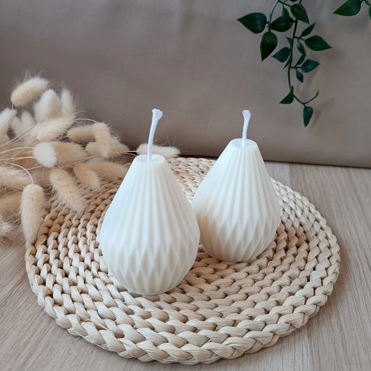 Dos velas artesanales de soja en forma geométrica estilo origami sobre base de fibras naturales